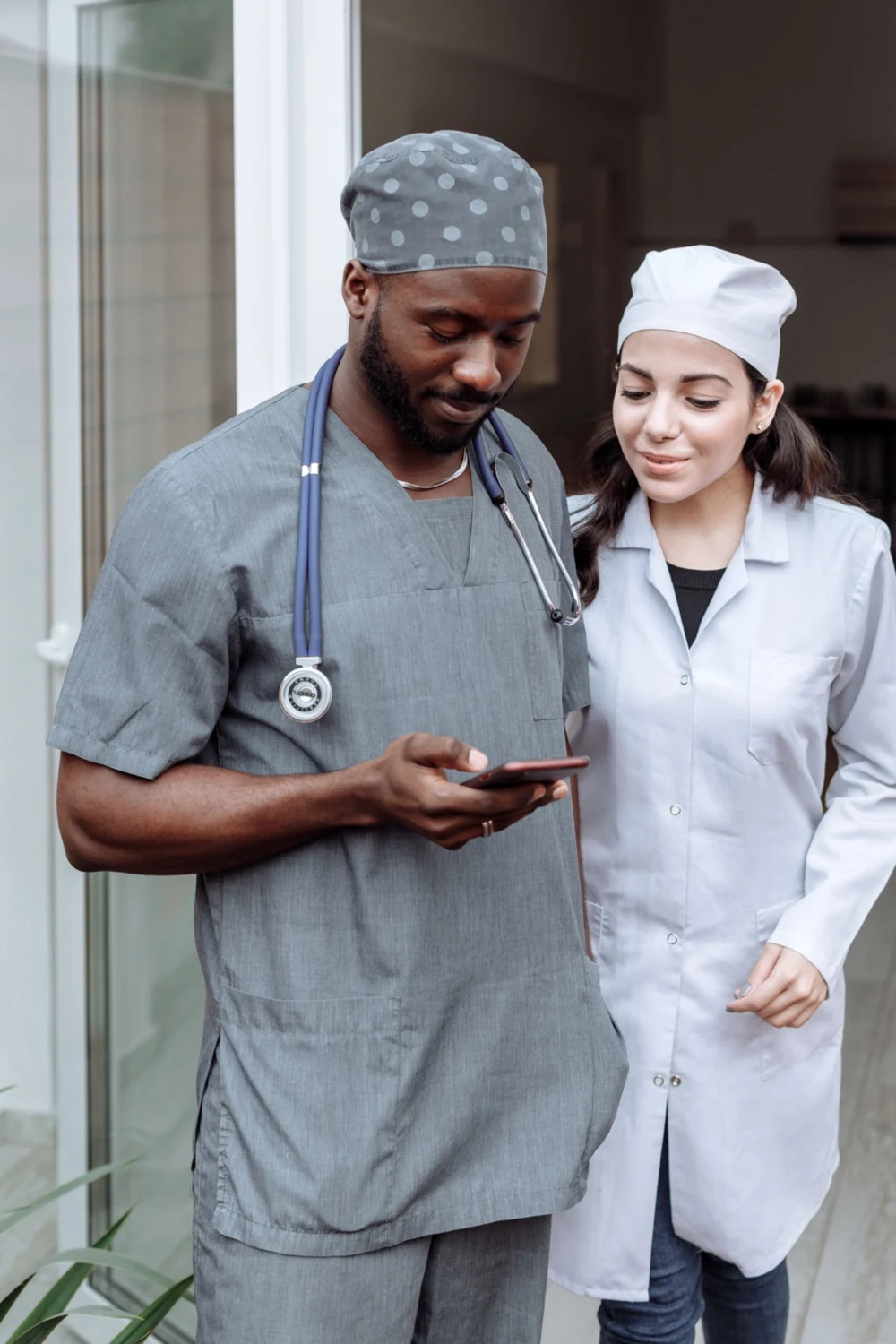 Two healthcare professionals reviewing a phone together